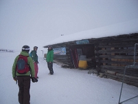 3 leute vor hütte